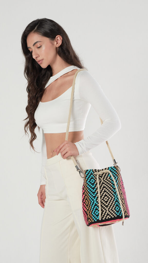 Wayuu bag with a geometric pattern in blue, khaki, and pink colors.