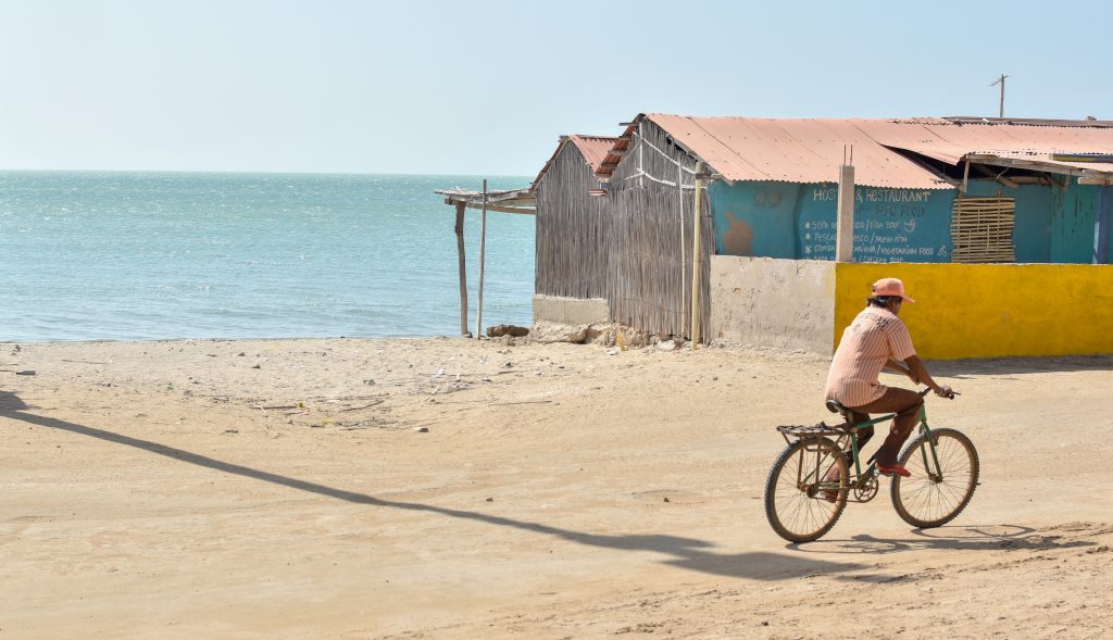 Hombre andando en bicicleta por la playa en el caribe