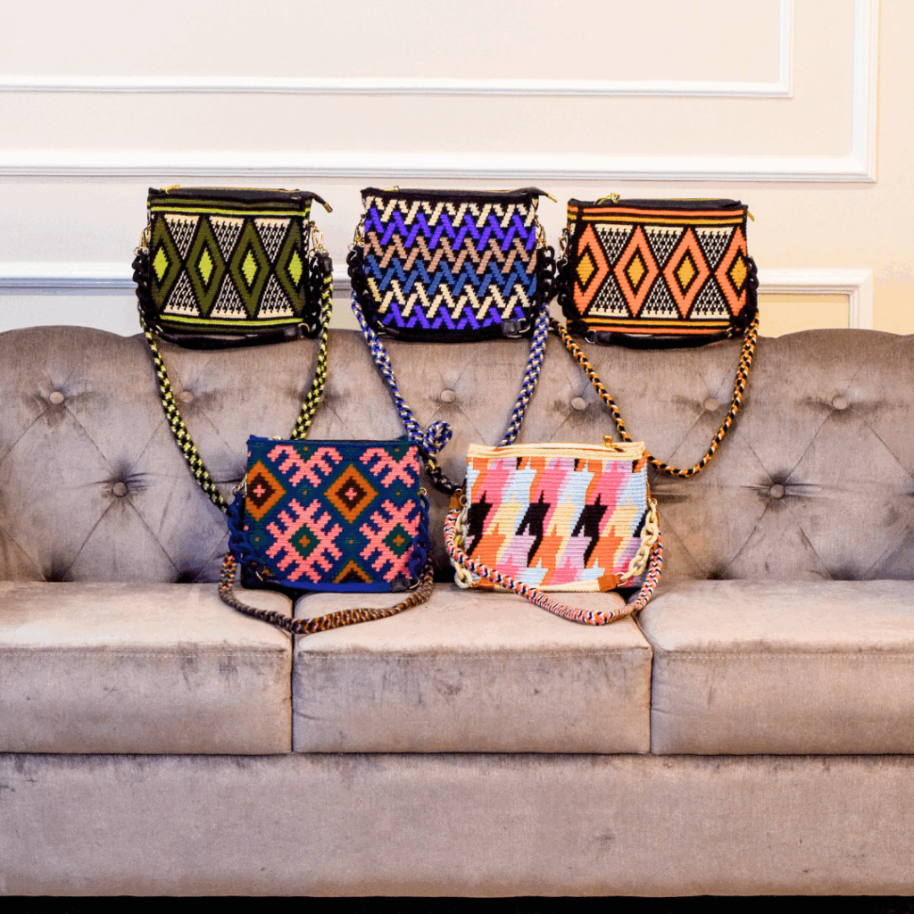 Wayuu bag sale featuring multiple Wayuu bags with various patterns and styles displayed on a sofa.