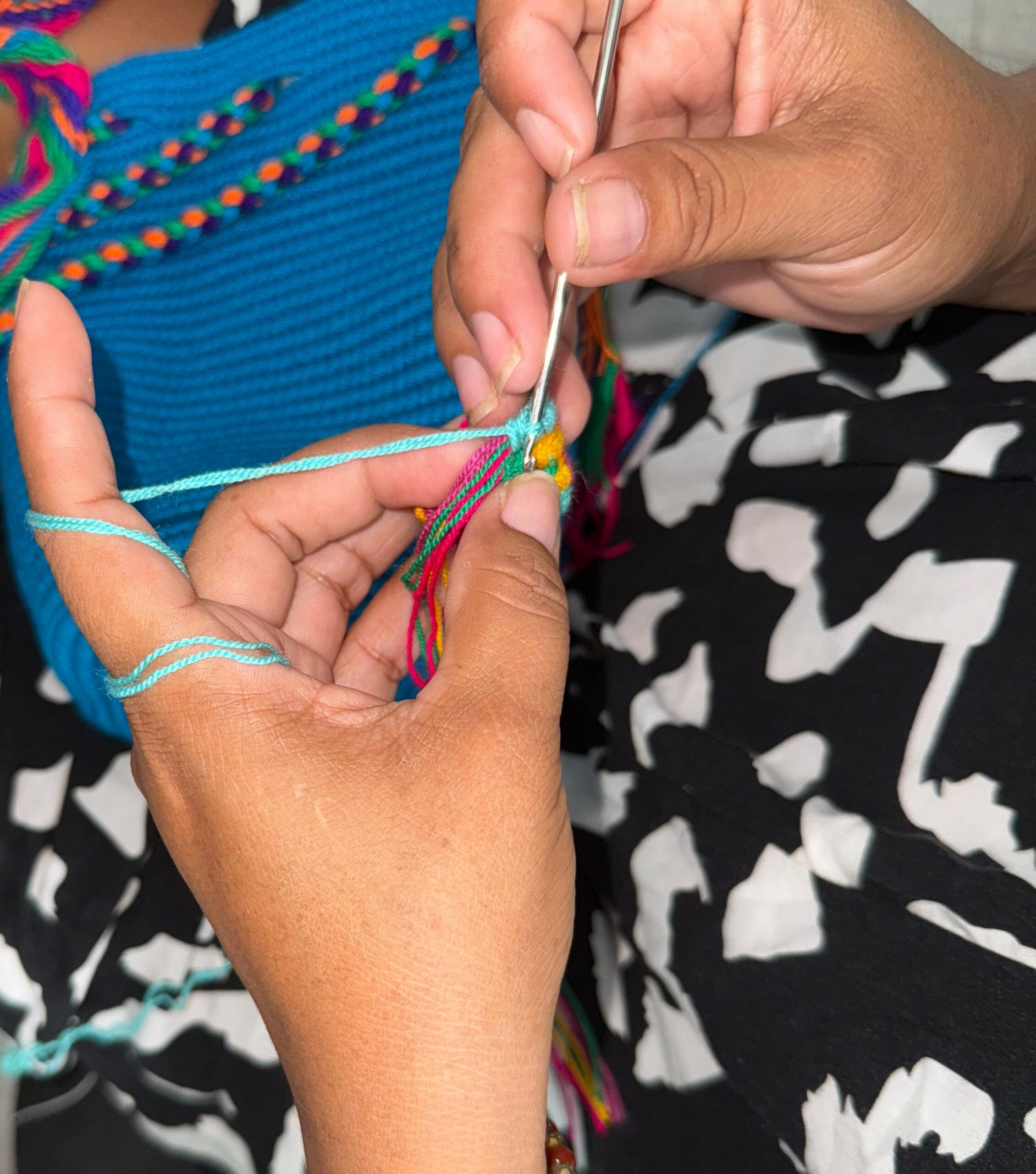 A photo of hands showcasing the Wayuu weaving techniques.