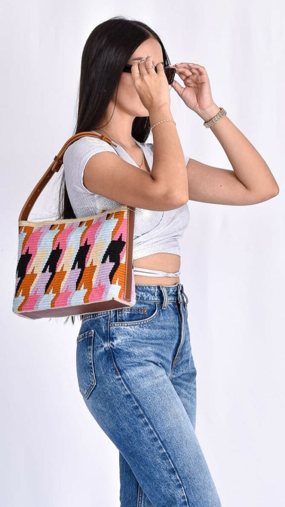 Maisie Wayuu Bag, handmade Colombian bag with vibrant blue, pink, and black geometric patterns, medium size with adjustable shoulder strap.