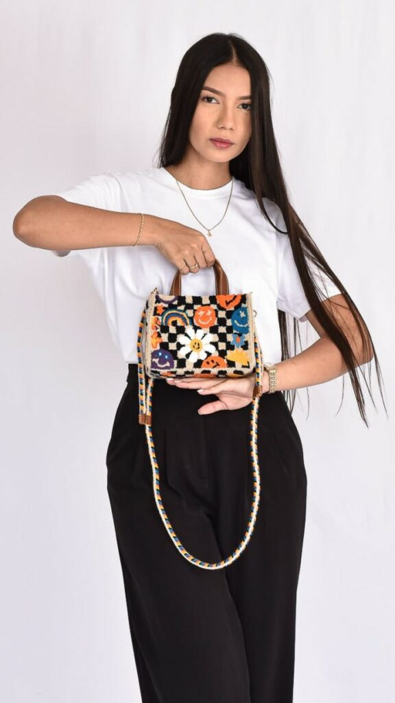 Brielle Small Wayuu Bag, handcrafted Colombian crochet bag in beige, orange, and black with double handles and compact square design.